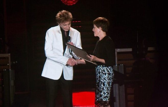 Barry Manilow on stage receiving an award.
