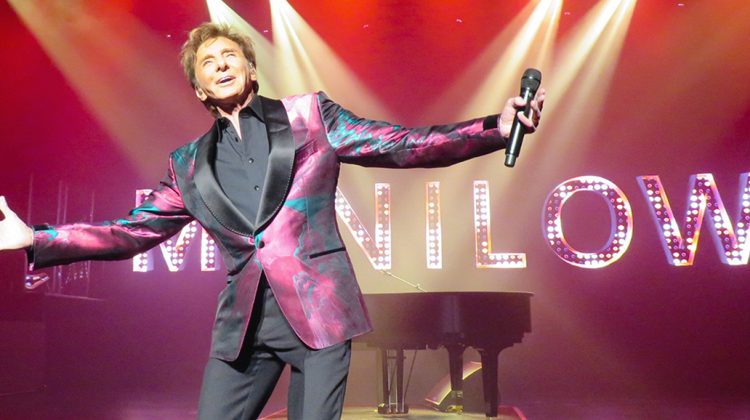 Barry Manilow on stage with his arms stretched out.